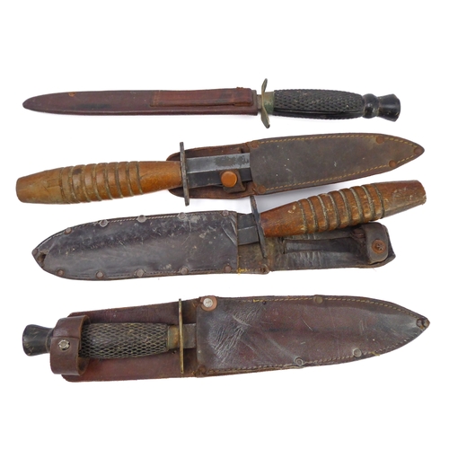 75 - Four commando-style daggers: 
 2 similar with chequered ebonised handles and their ricassos marked '... 