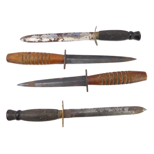 75 - Four commando-style daggers: 
 2 similar with chequered ebonised handles and their ricassos marked '... 