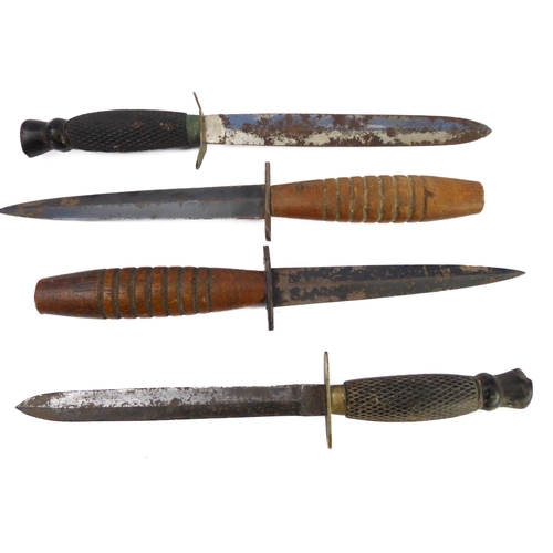 75 - Four commando-style daggers: 
 2 similar with chequered ebonised handles and their ricassos marked '... 