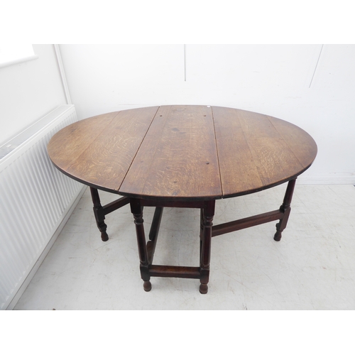 387 - An 18th century oval oak gateleg table: the well-figured top with medullary rays above a plain friez... 