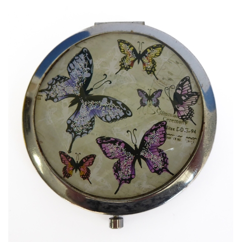 189 - A mid-20th century circular powder compact, faceted glass lid decorated with glitter butterflies (ca... 