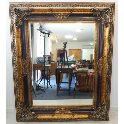 238 - A large and extremally elaborate gilt-framed wall-hanging looking glass in 19th century style (good ... 