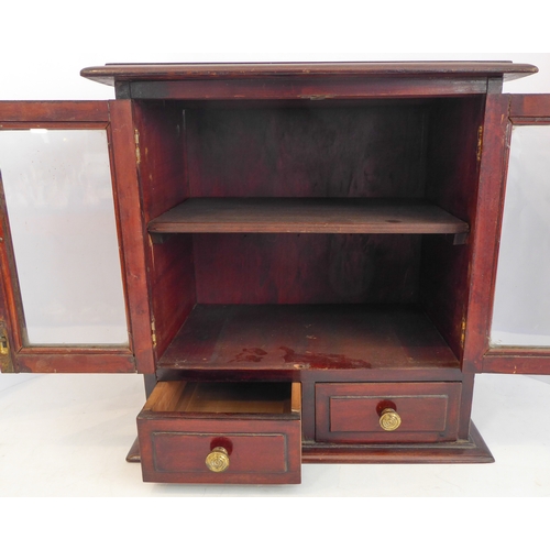 202A - A late 19th/early 20th century mahogany table cabinet: the moulded top above two glazed doors enclos... 