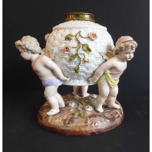 17 - A late 19th century hand-decorated continental porcelain lamp-base: modelled as three cherubs suppor... 