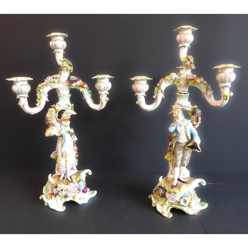 21 - A pair of late 19th century figural German porcelain four-light candelabra: meticulously applied flo... 