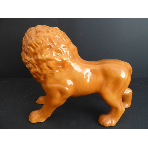 33 - A mid to late 19th century standing lion Staffordshire pottery figure (36 cm wide)