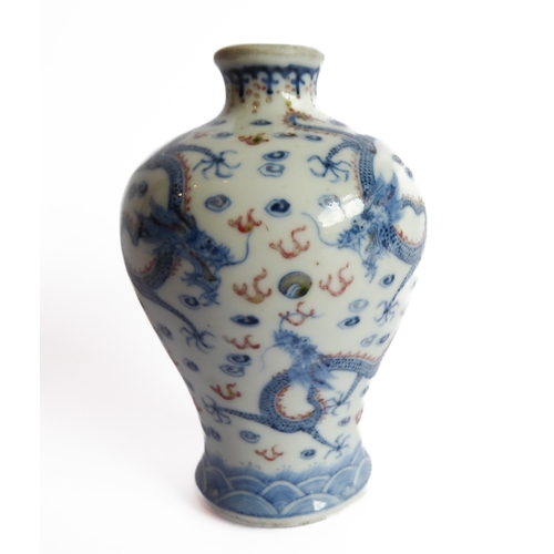 40 - A small Chinese vase decorated with five-claw dragons chasing flaming pearls in a red and blue palle... 