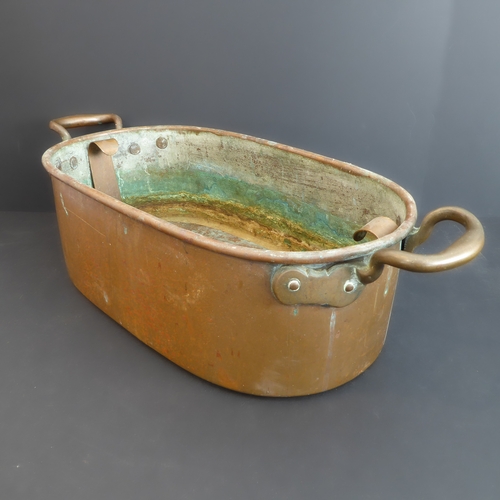 86 - A heavy copper fish kettle (55cm wide x 20cm high, approx. 6kg)