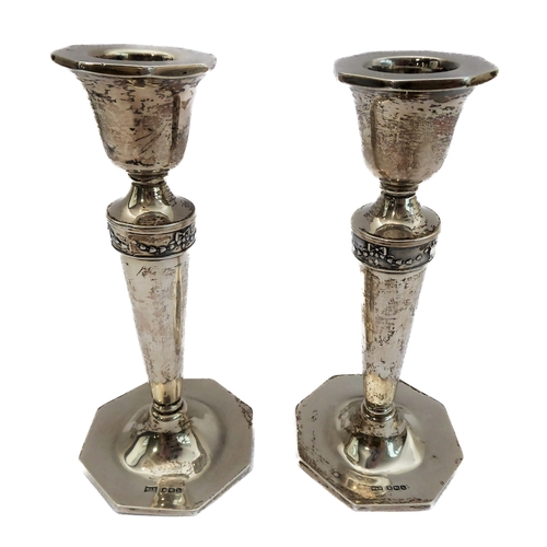 200 - A pair of neo-classical style tapering candlesticks with a relief band of swags and bows, tapering d... 