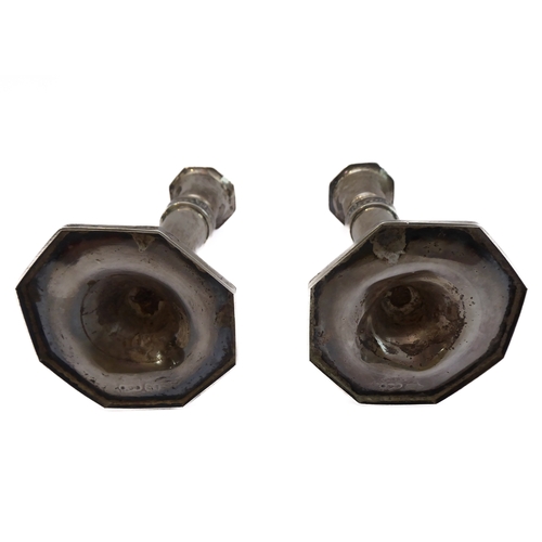 200 - A pair of neo-classical style tapering candlesticks with a relief band of swags and bows, tapering d... 