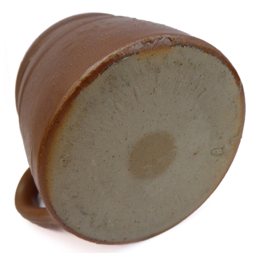 55 - Seven salt-glazed stoneware ale tankards each with ribbed strap handles, together with a Doulton Lam... 