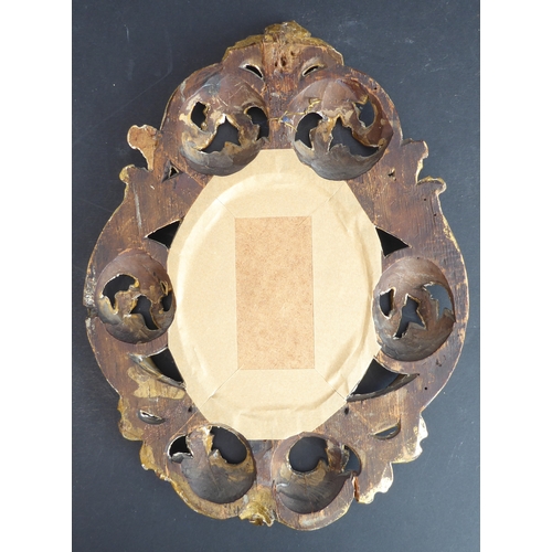 505 - A 19th century carved giltwood Florentine style picture frame: pierced in high relief with various s... 