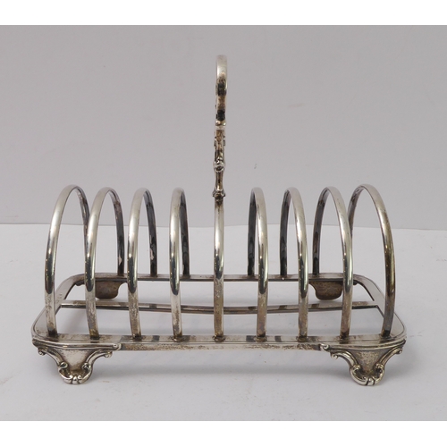 207 - A large early Victorian hallmarked silver eight-division toast-rack: the cast scrolling handle with ... 