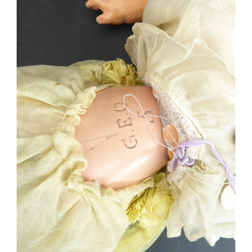 410 - A mid-20th century blue sleeping-eyes doll in a light-yellow bonnet and similar dress, the back of t... 