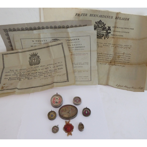 356 - A fascinating collection of seven mostly white metal and glazed religious pendant reliquaries relati... 