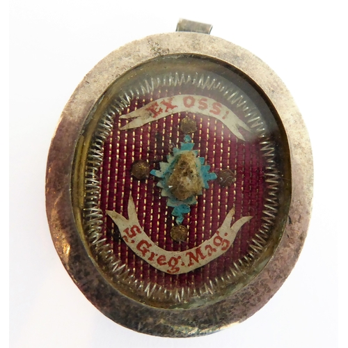 356 - A fascinating collection of seven mostly white metal and glazed religious pendant reliquaries relati... 