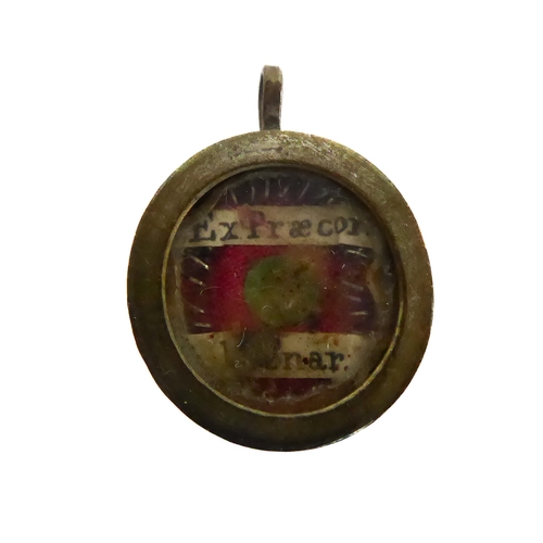 356 - A fascinating collection of seven mostly white metal and glazed religious pendant reliquaries relati... 