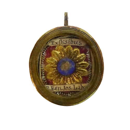 356 - A fascinating collection of seven mostly white metal and glazed religious pendant reliquaries relati... 