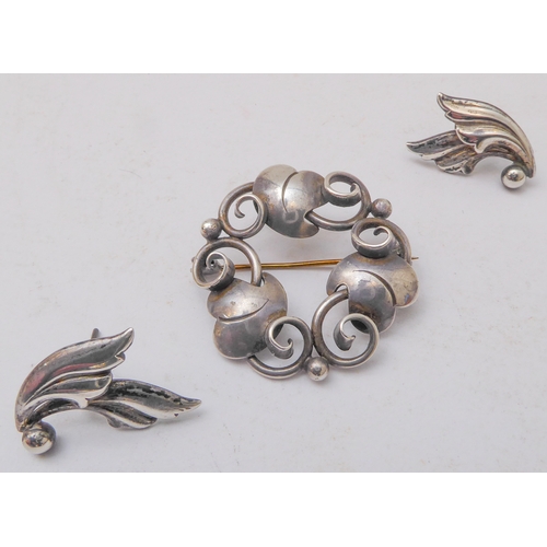 129 - A Georg Jensen design silver-coloured brooch, together with a small pair of Jensen silver leaf-desig... 