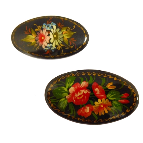 131 - Two Russian oval papier-mâché brooches: hand-decorated with enamels with floral sprays