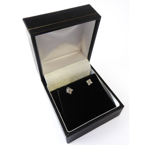 143 - A pair of 18-carat white gold ear studs, each set with a single old cut diamond, total diamond weigh... 