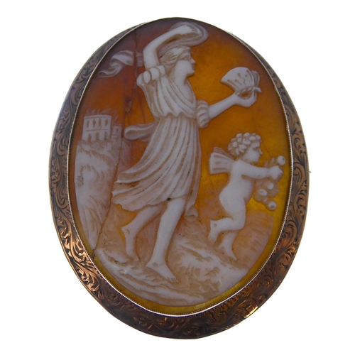 155 - Two oval shell cameo brooches: the first depicting a seated lady reading to Cupid within a collet an... 