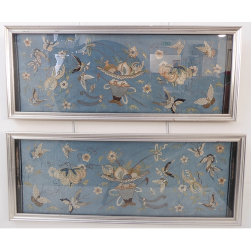 227 - A pair of silver framed and glazed (later) Chinese embroideries on silk: each depicting a central ur... 