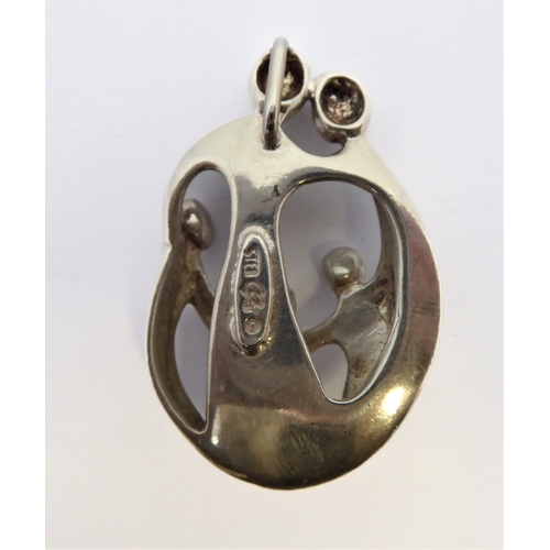 280 - A sterling silver pendant modelled as a stylised family with mother, father and three children befor... 