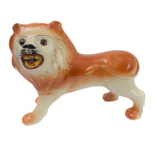 79 - A large opposing pair of late 19th century Staffordshire lions: each with glass eyes, open mouthed a... 