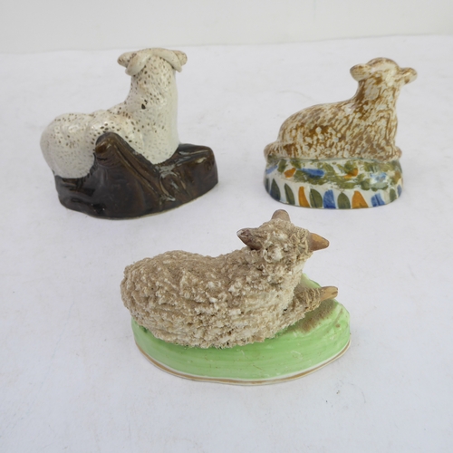 29 - Two 19th century models of recumbent sheep and a later similar porcelain model (the largest 9.5cm hi... 