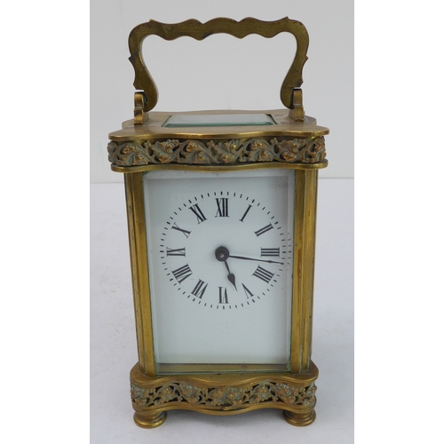 291 - A late 19th to early 20th century French gilt-brass and glass-sided carriage clock: the shaped handl... 