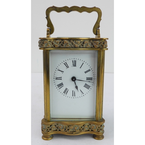 291 - A late 19th to early 20th century French gilt-brass and glass-sided carriage clock: the shaped handl... 