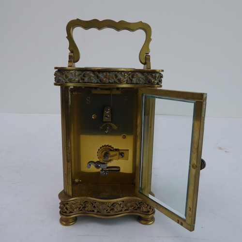 291 - A late 19th to early 20th century French gilt-brass and glass-sided carriage clock: the shaped handl... 