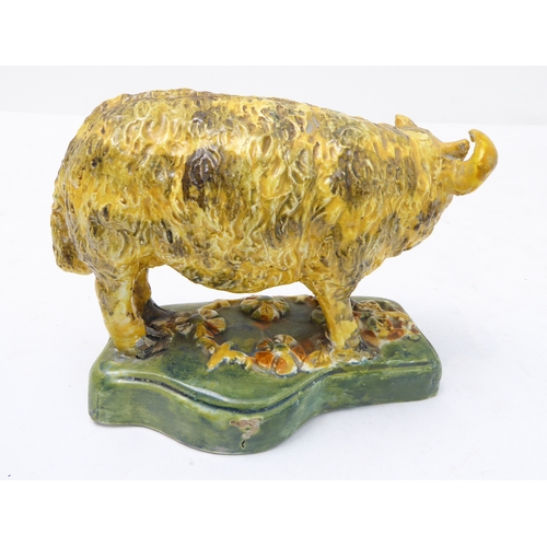 56 - A late 18th to early 19th century Pearlware model of a ram lamb in yellow glaze and with curling hor... 