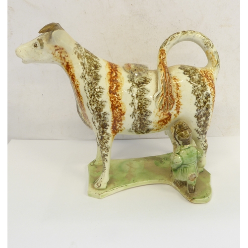 51 - A pair of early 19th century English pearlware milkmaid cow creamers: stripped brown and umber spong... 