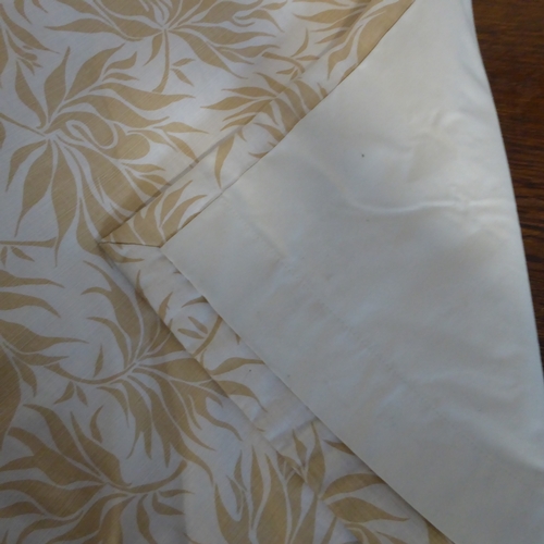 405 - A pair of curtains in a heavy cream linen-effect fabric with gold leaf pattern; triple pinch pleat h... 