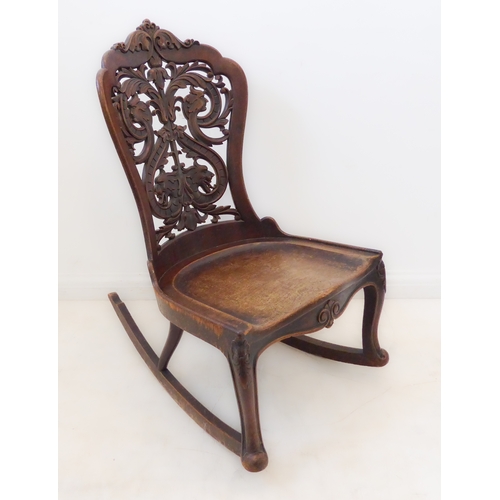 412 - An unusual 19th century continental mahogany rocking chair: the pierced back with scrolling acanthus... 