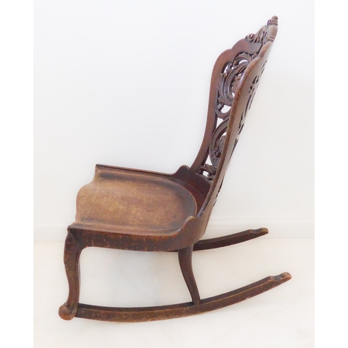 412 - An unusual 19th century continental mahogany rocking chair: the pierced back with scrolling acanthus... 