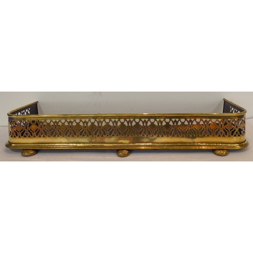 115 - A compact 19th century brass fire fender: pierced and decorated with stylised shapes and central urn... 