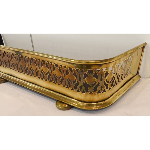 115 - A compact 19th century brass fire fender: pierced and decorated with stylised shapes and central urn... 