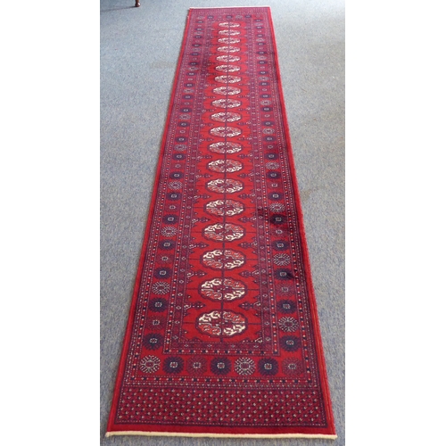 401 - A red ground machine-made Persian-style runner with gul pattern (365 x 69 cm)