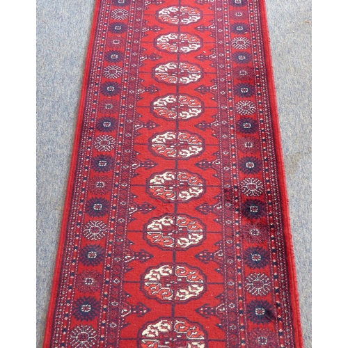 401 - A red ground machine-made Persian-style runner with gul pattern (365 x 69 cm)