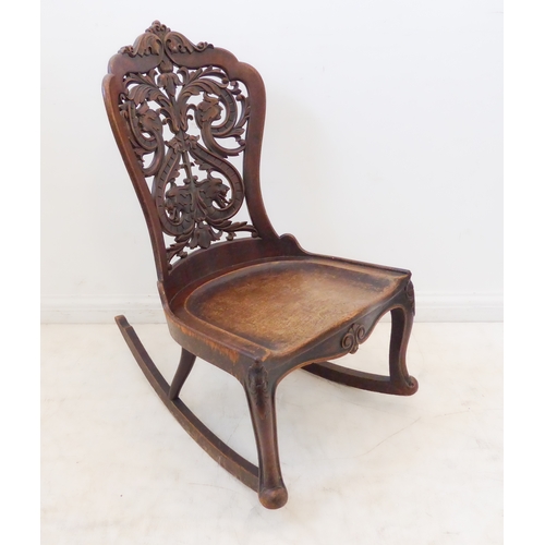 412 - An unusual 19th century continental mahogany rocking chair: the pierced back with scrolling acanthus... 