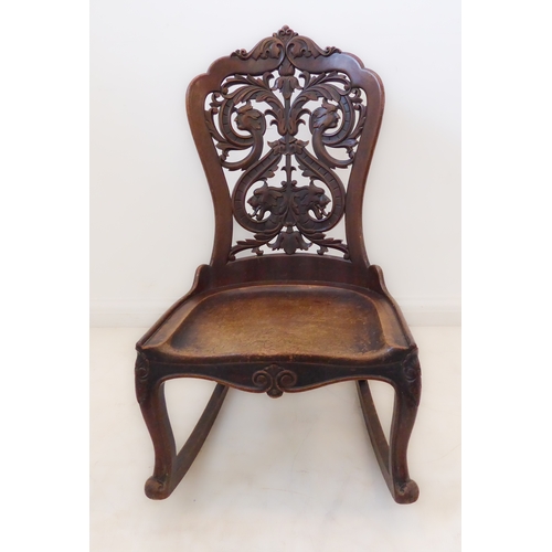 412 - An unusual 19th century continental mahogany rocking chair: the pierced back with scrolling acanthus... 