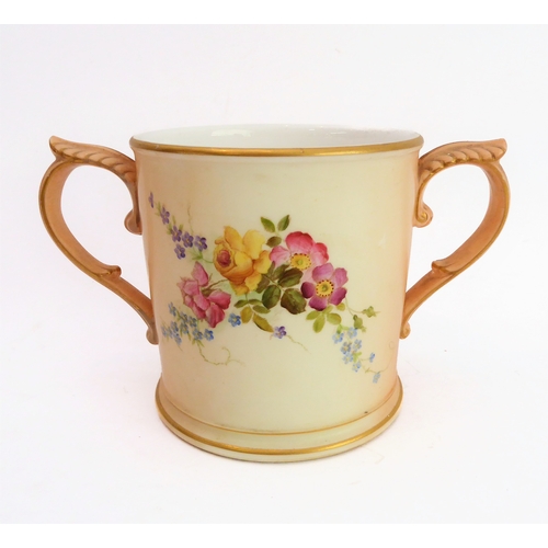 32 - An early 20th century Royal Worcester blush porcelain loving cup: two-handled and hand-decorated in ... 