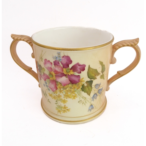 32 - An early 20th century Royal Worcester blush porcelain loving cup: two-handled and hand-decorated in ... 
