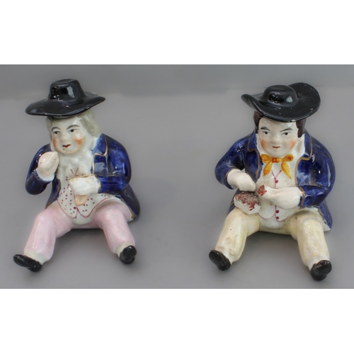 31 - A pair of 19th century seated Staffordshire figures (as pots with removeable hats, minor damage) (8.... 