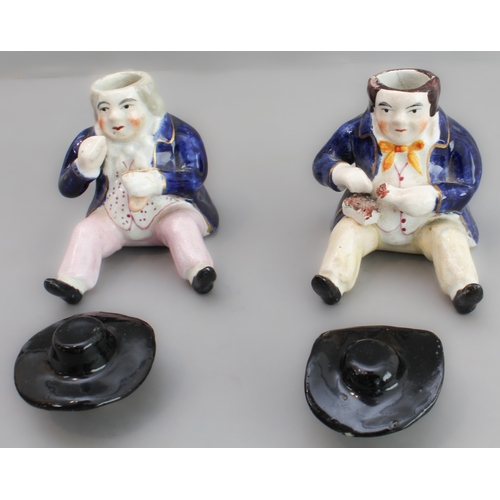 31 - A pair of 19th century seated Staffordshire figures (as pots with removeable hats, minor damage) (8.... 