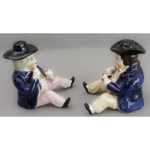 31 - A pair of 19th century seated Staffordshire figures (as pots with removeable hats, minor damage) (8.... 