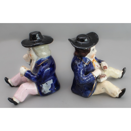 31 - A pair of 19th century seated Staffordshire figures (as pots with removeable hats, minor damage) (8.... 